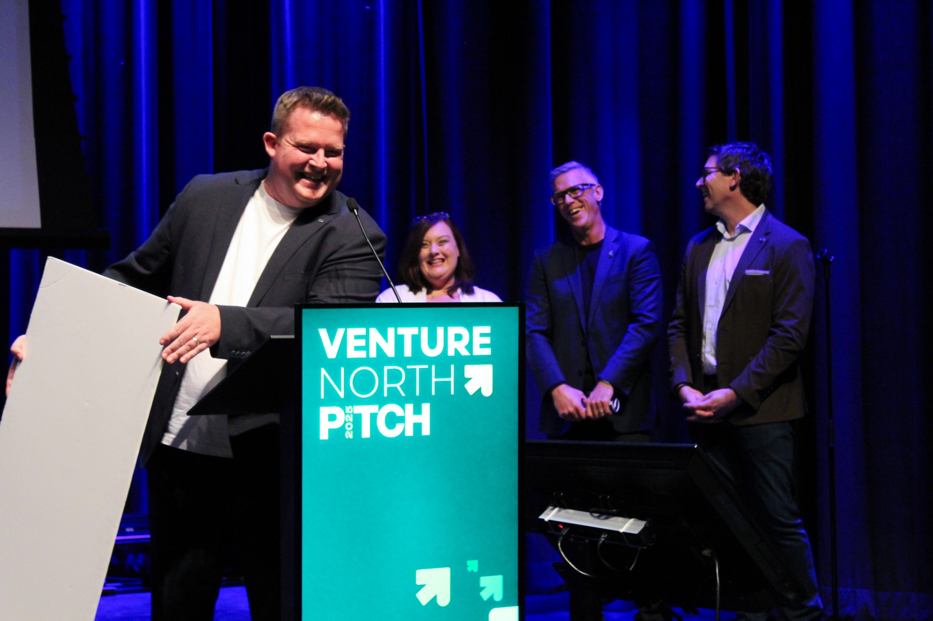Presenter delivering her pitch under the spotlight on the Venture North PITCH stage.